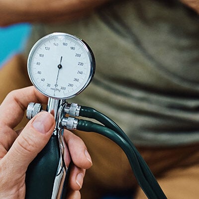 Mann wird beim Arzt Blutdruck gemessen