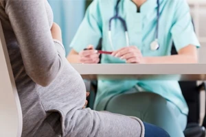Schwangere spricht mit Medizinerin