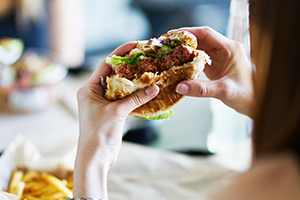 Frau isst Burger Diabetes