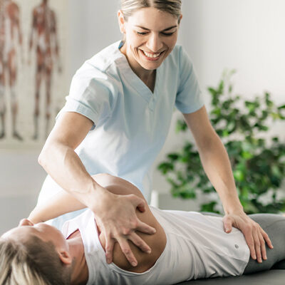 Physiotherapeutin macht Übungen mit Patienten